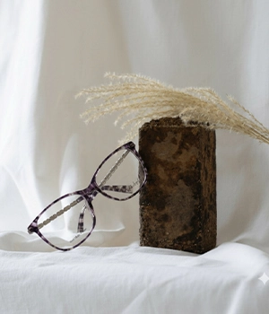 White Angel purple marble texture optical glasses on a stone with white fabric background.