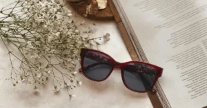 Elegant red eyewear frame next to book.