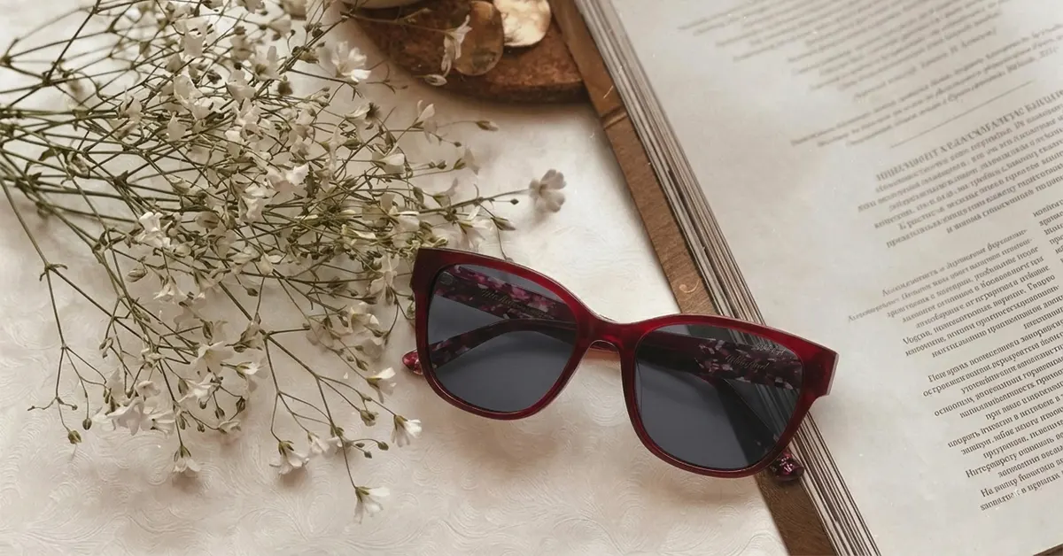 Elegant red eyewear frame next to book.